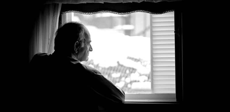 A Man Looking Out A Window | Hip Implant Attorney